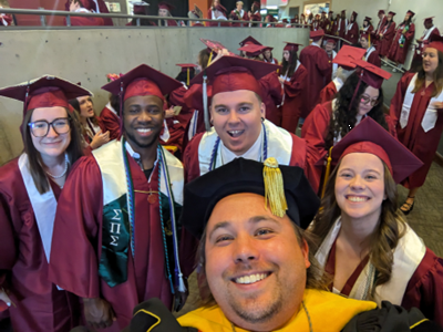 Professor Kuwada and the 2024 physics gradutes smiling.