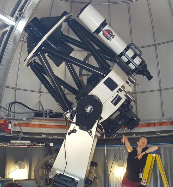 Dr. Fallscheer pointing at the CWU Observatory research telescope while it slews to a new location.