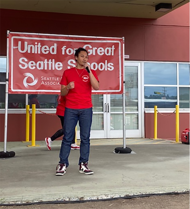 Girard Montejo-Thompson stands in front of a Seattle school building.