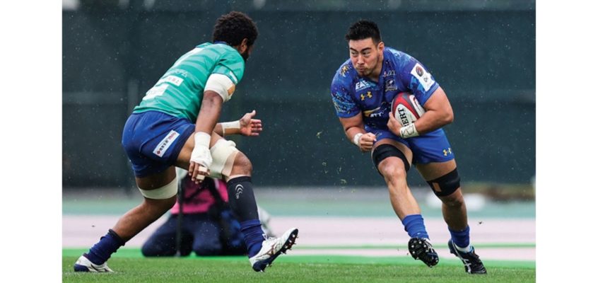 Alex Mackenzie running towards another rugby player while holding the ball.