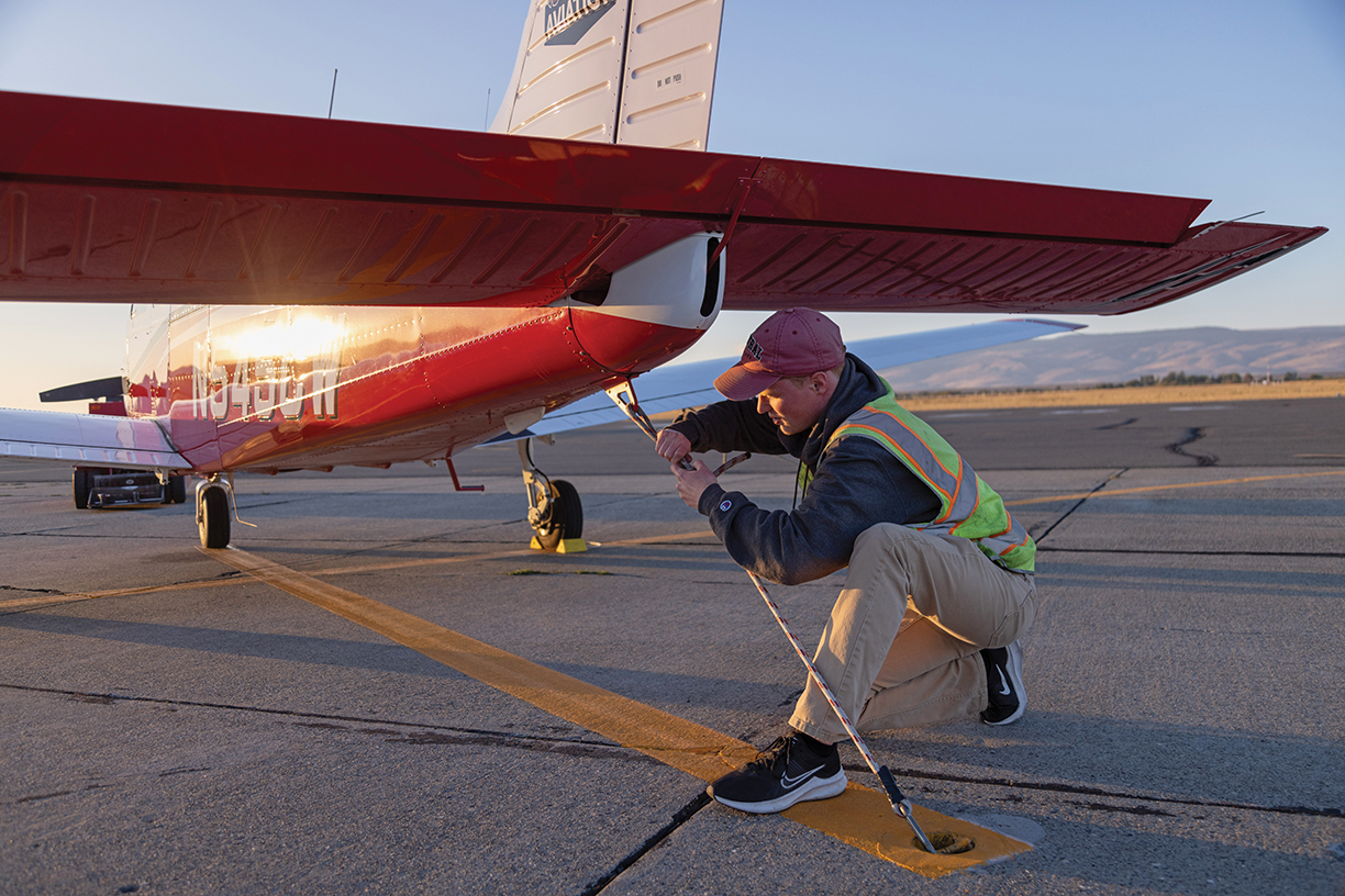 A CWU aviation technician works on a plane