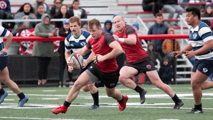 Two CWU rugby players are seen trying to outplay 3 members of the opposite team