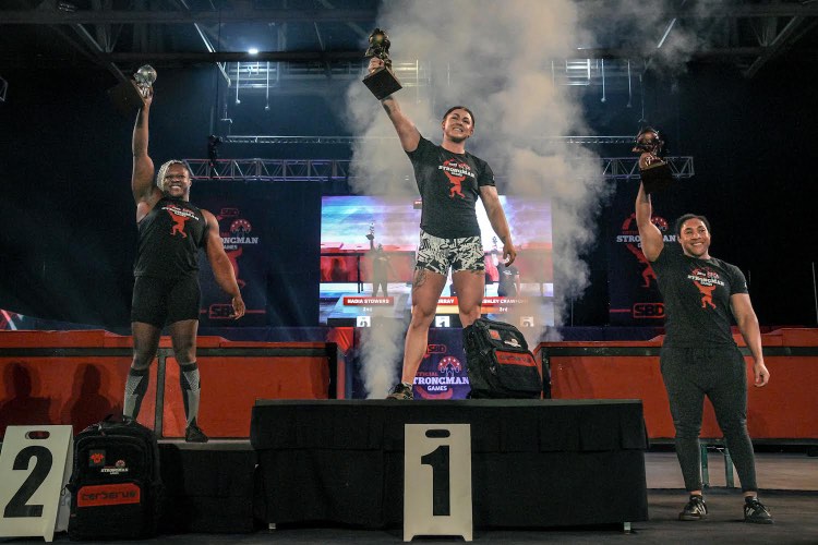 Erin Murray stands atop an awards podium