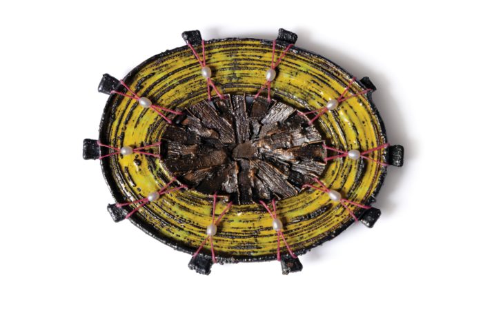 Unknown piece of jewelry with yellow as its main color, elliptical shape