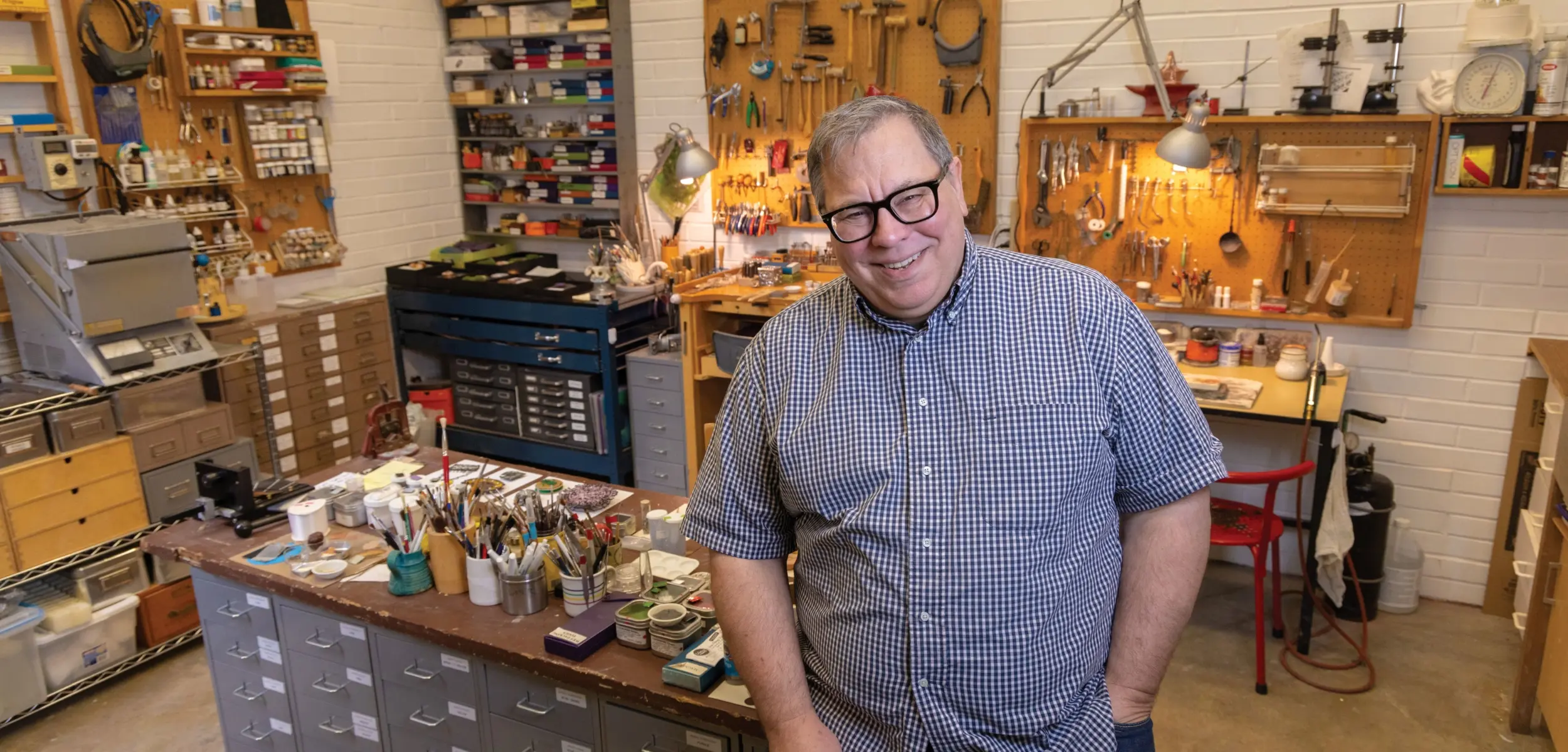 Keith Lewis standing in front of his workshop, facing the camera.