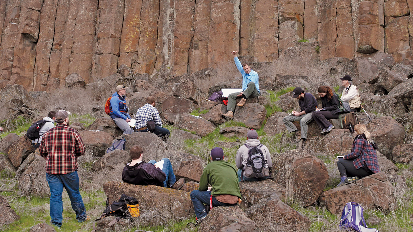 Photo of Nick Zentner teachging a class near some impressive-looking basalt columns.
