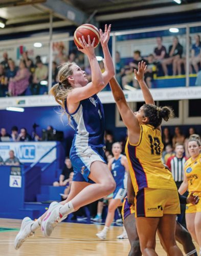 Sam Bowman jumping to throw the ball while playing basketball.