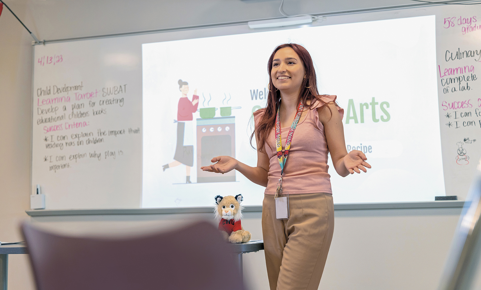 Photo of Ingrid Valencia in her classroom, striking a cool pose.