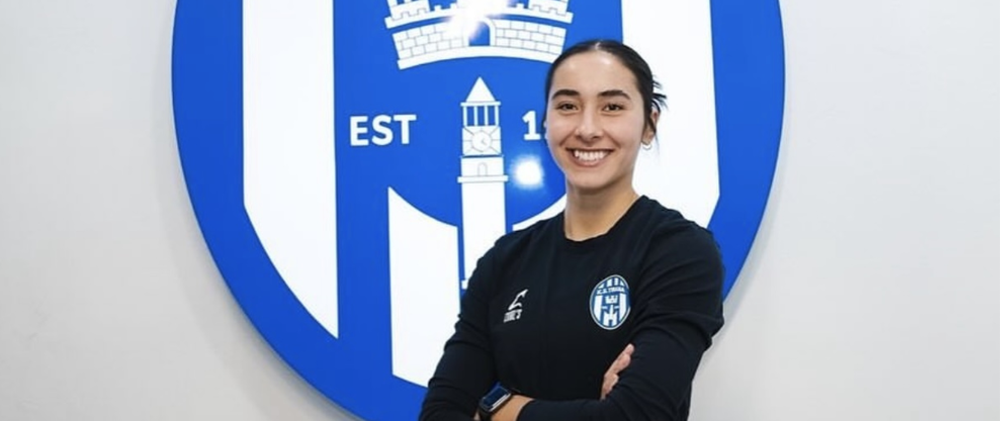 Tia Andaya in front of her club team's logo