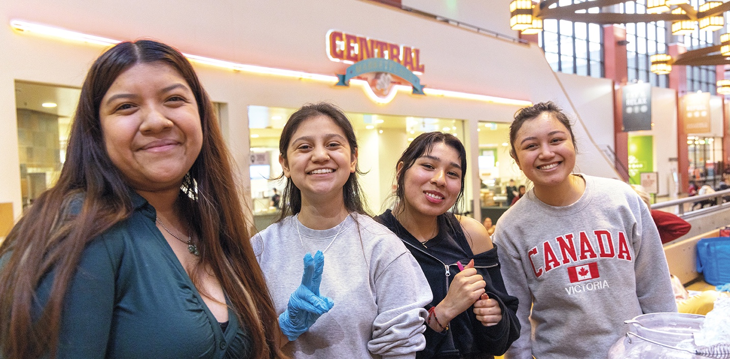 Four students smiling inside the SURC