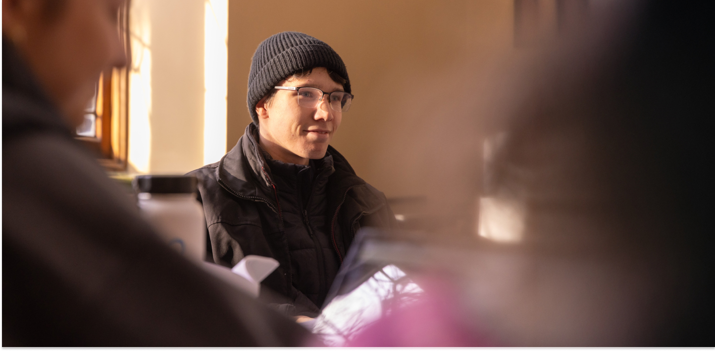 Student paying attention in class wearing all black and glasses.