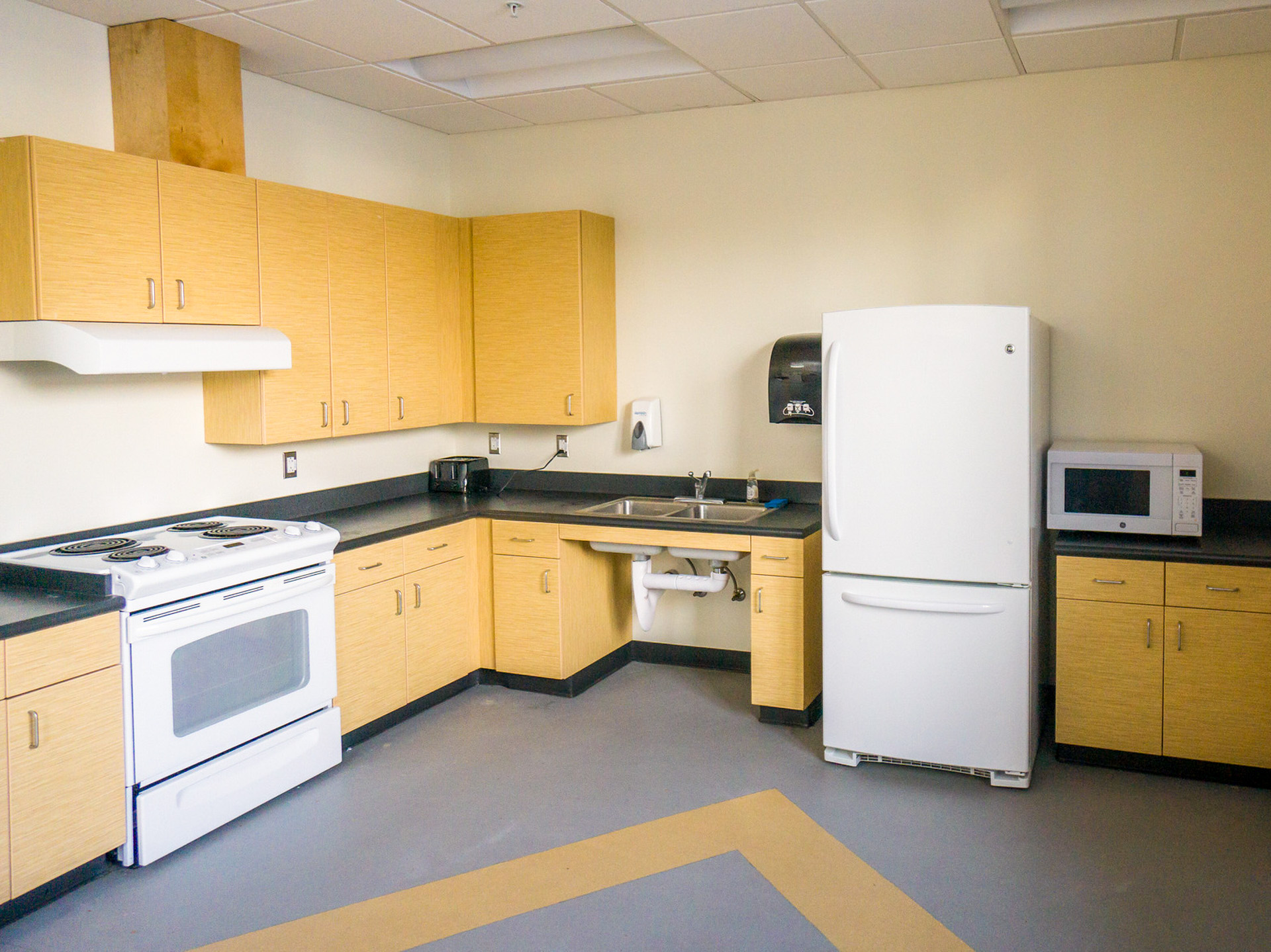 Kitchen in Barto showing a fridge, oven, sink, and microwave