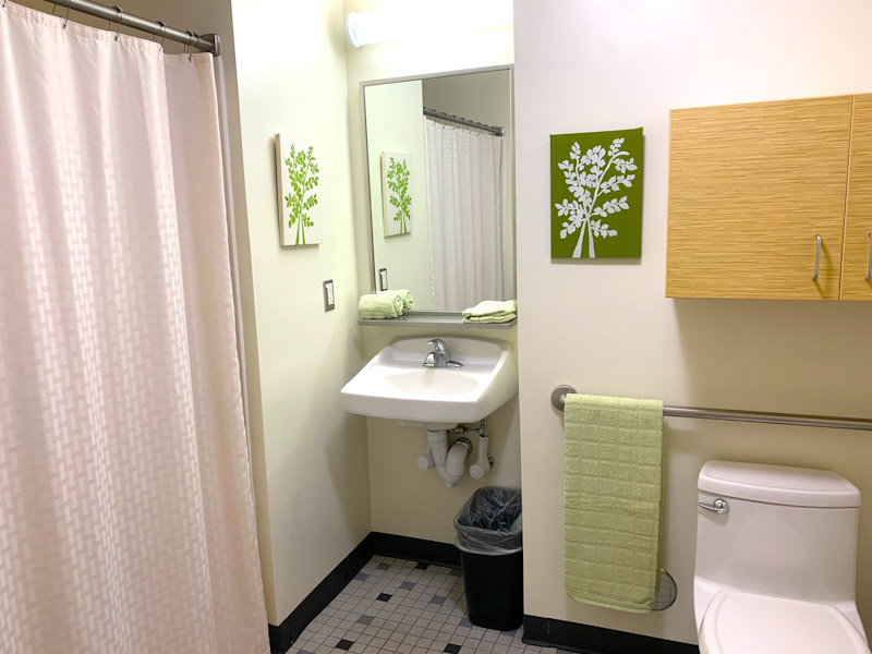 Bathroom in a Barto suite-style room with toilet, sink, and shower
