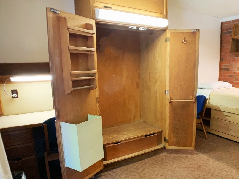 An open closet showing the closet rod and storage on the inside of the closet door
