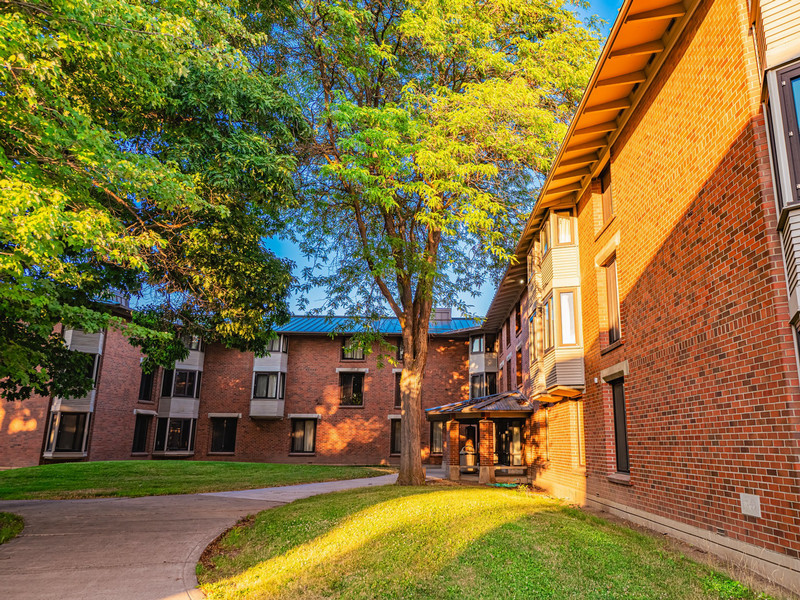 Three-story brick residence hall with covered porch entrance