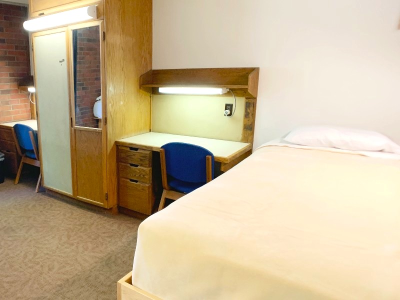 Room with twin XL bed, desk, and closet