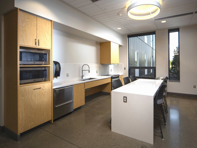 First floor lounge with kitchen, bar seating, and chairs