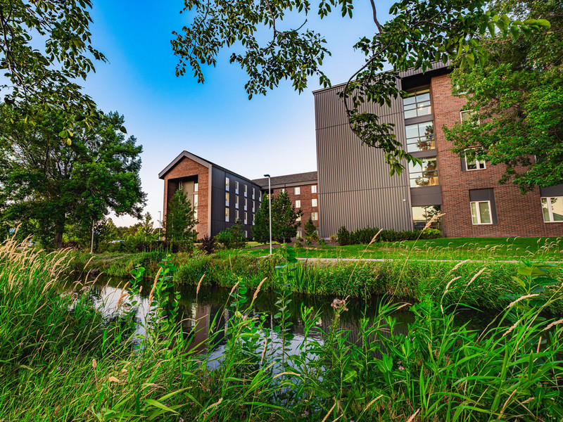 Four-story modern residence hall in natural setting
