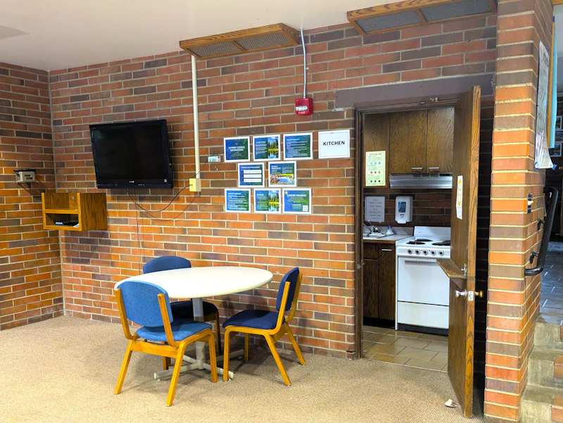 Kitchen area with stove, table, and chairs