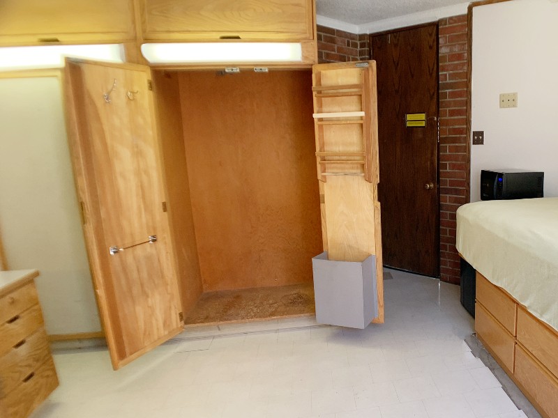 Open closet showing clothes bar and towel bars on the inside doors