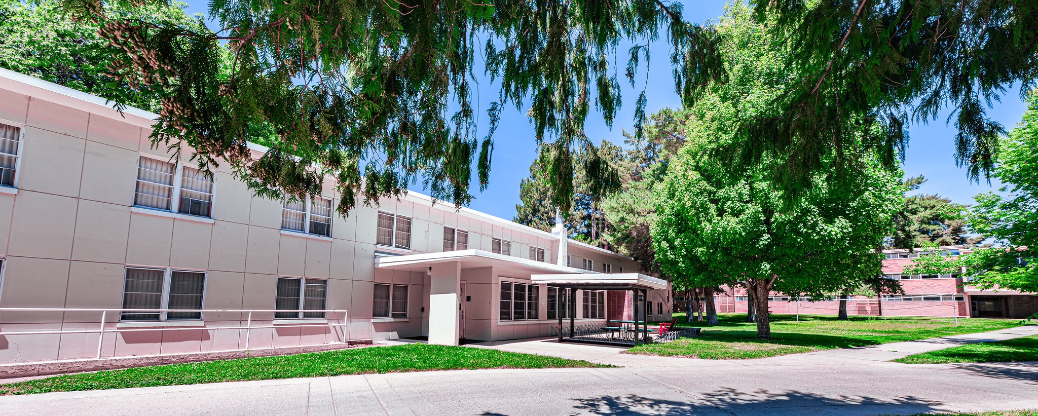 White two-story residence hall in summer