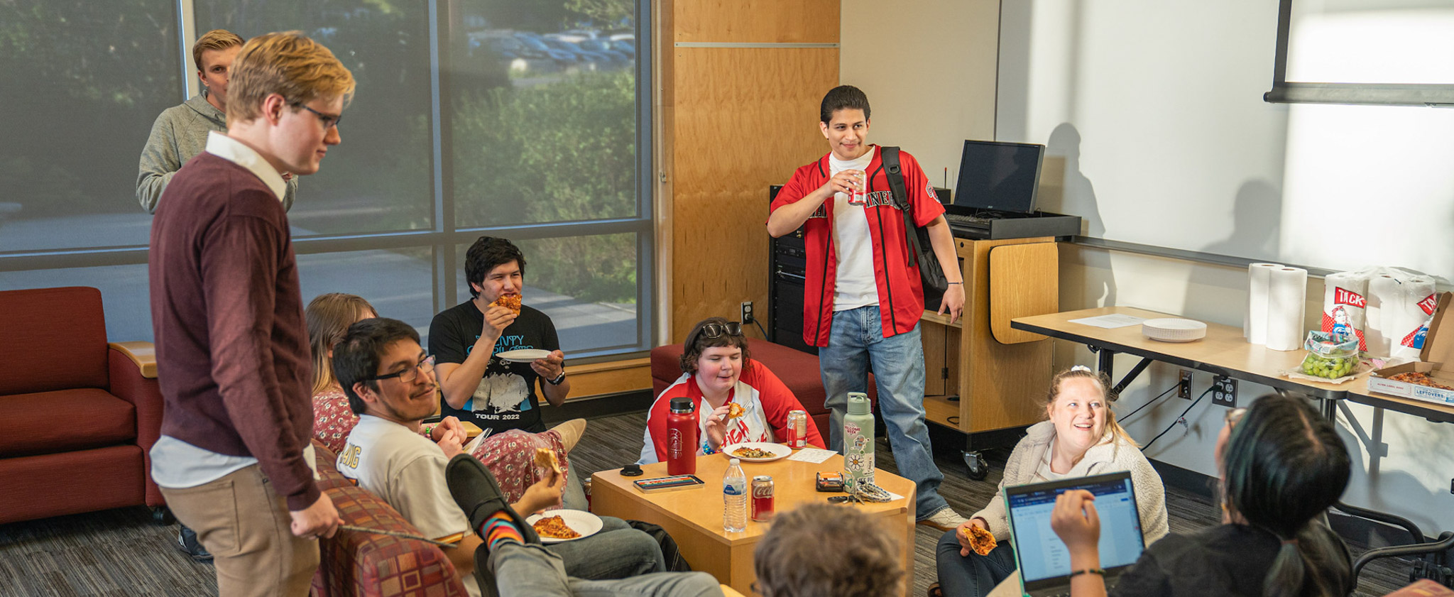 Students eating and visiting in a residence hall lounge