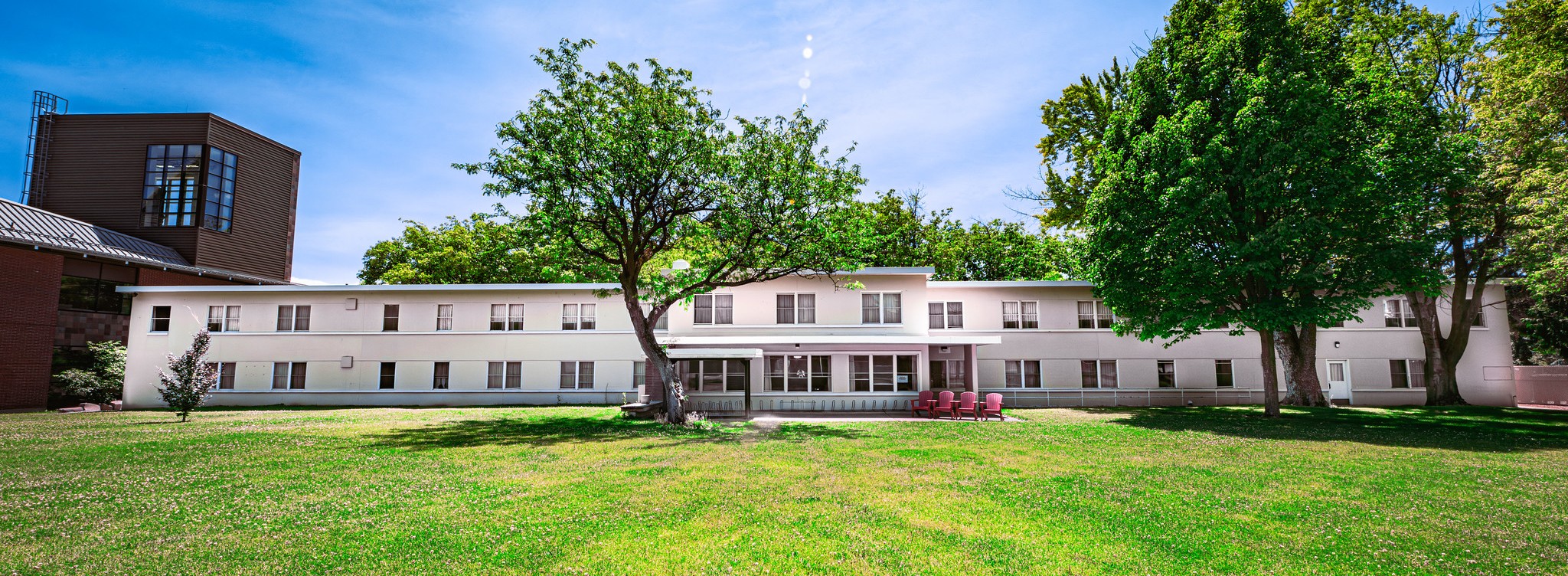 Two-story white residence hall with green lawn