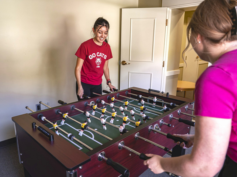Two students playing at a game table