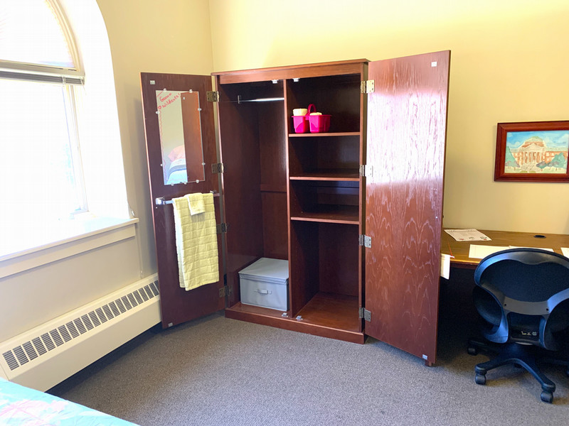Closet with a hanging rod, shelves, and a towel bar