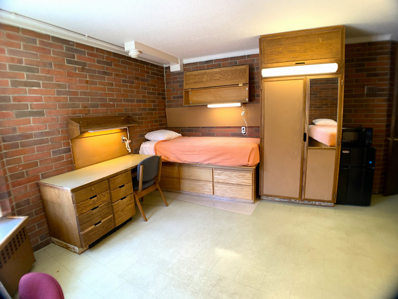 Twin XL bed between a desk and closet