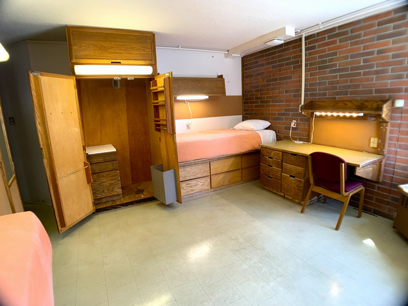 Open closet showing clothes bar and towel bars on the inside doors