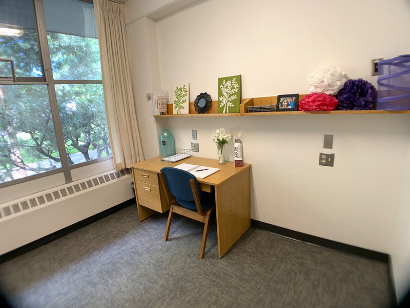 Desk and shelves on the wall with a large window