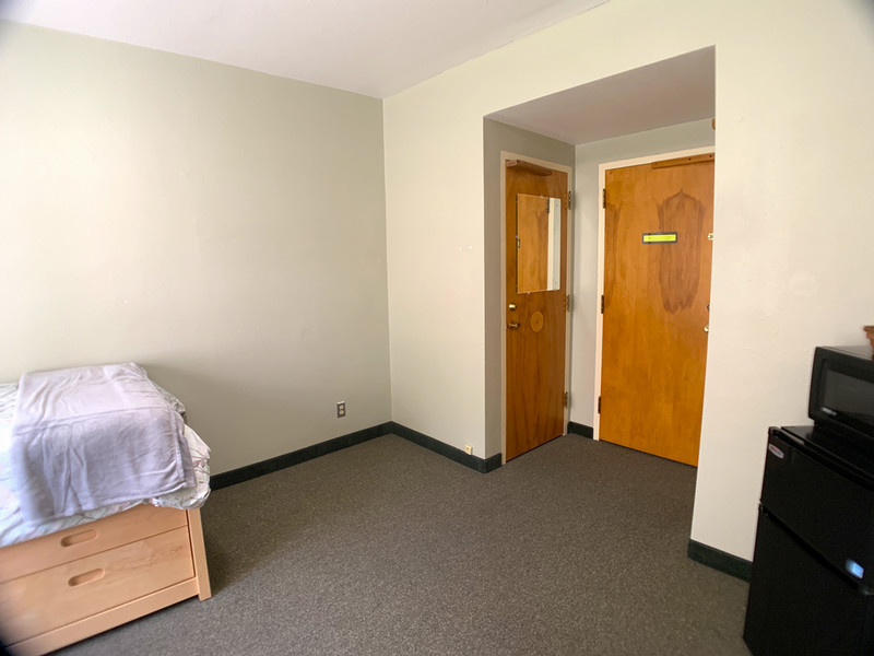 Corner of room with other closet door and entrance door