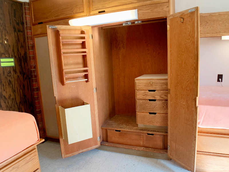 Open closet showing clothes bar and drawers on the inside