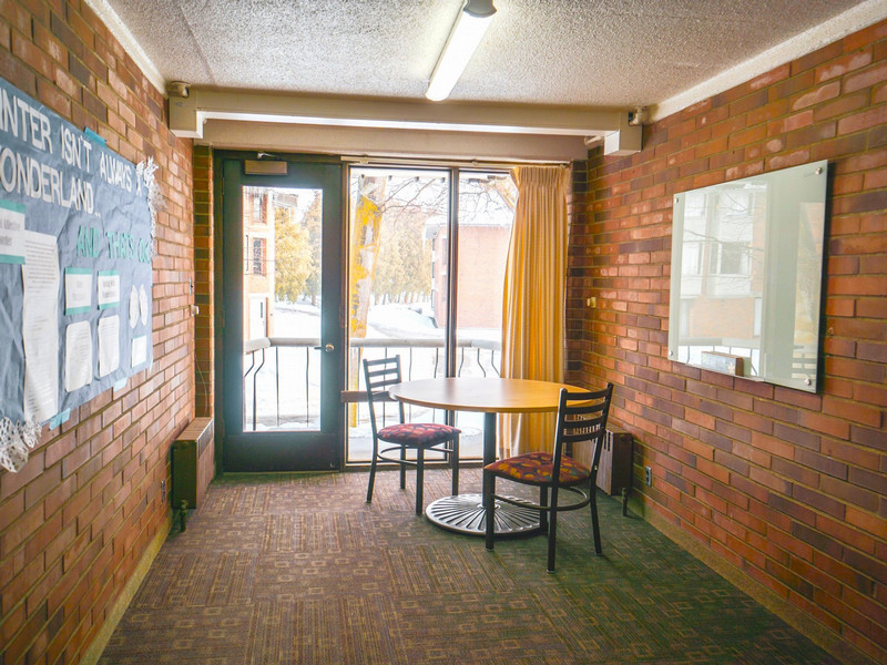 Study room with table, chairs, and a white board by a large window