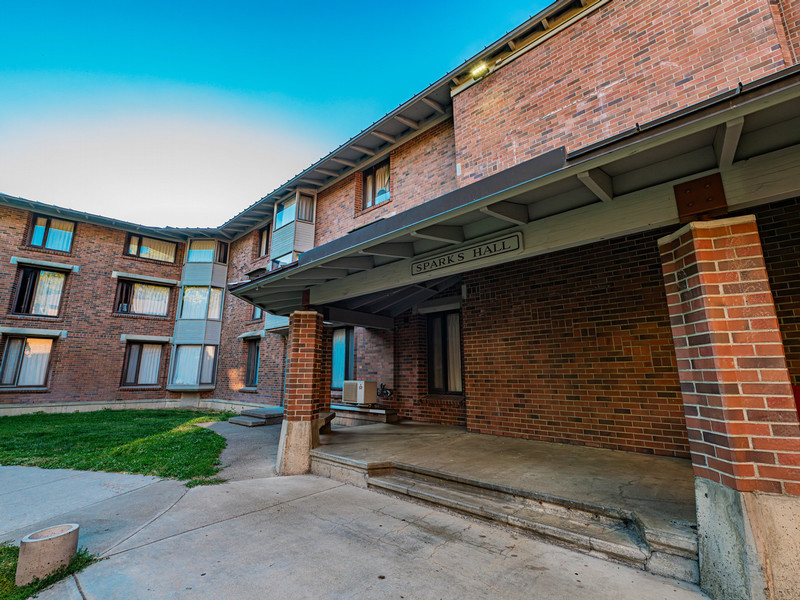 Brick 3-story residence hall with a covered porch entrance