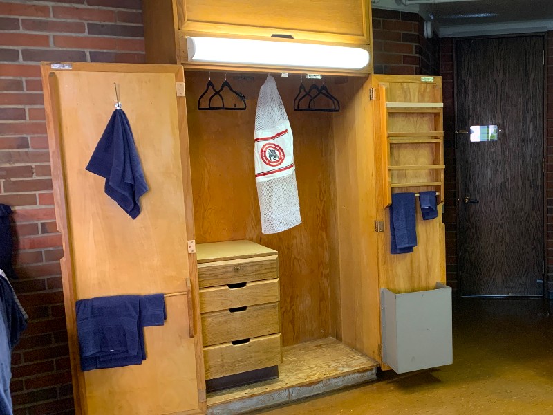 Open closet showing clothes bar and towel bars on the inside doors
