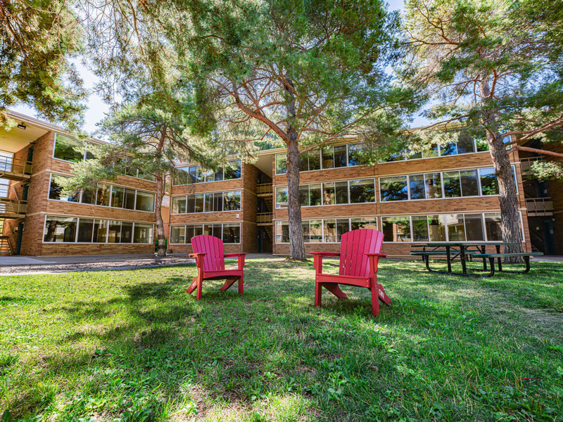 Three-story brick residence hall with inner courtyard with picnic tables and grills