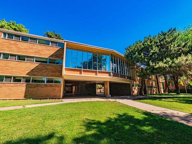 Brick three-story residence hall in the summer time