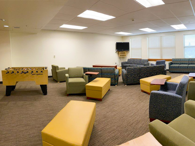 Lounge with game table, chairs, couches, and a TV