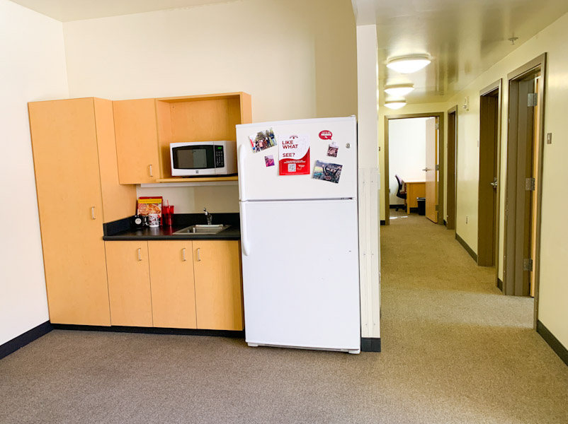 Kitchenette area with fridge, sink, and pantry