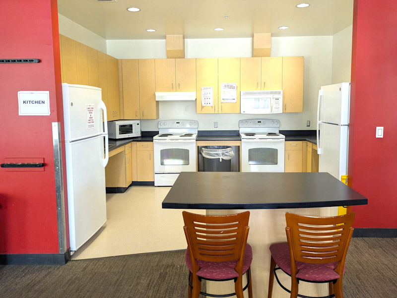 Kitchen with two stoves, two refrigerators, a microwave, and two sinks