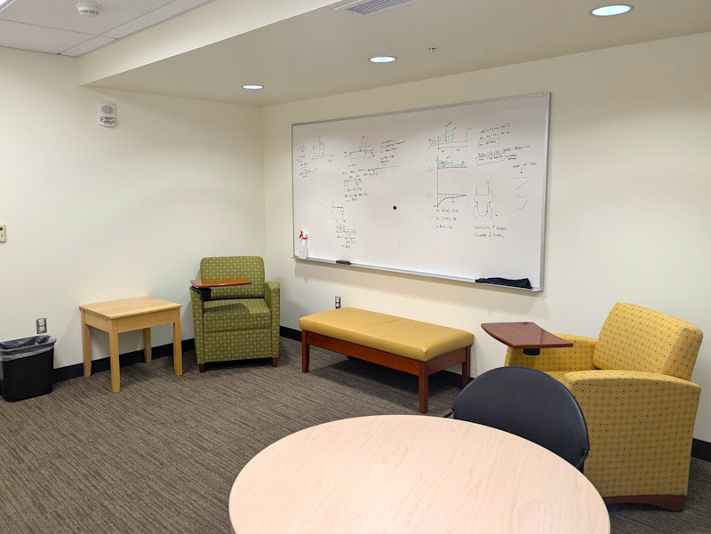Study lounge with chairs, table, and whiteboard