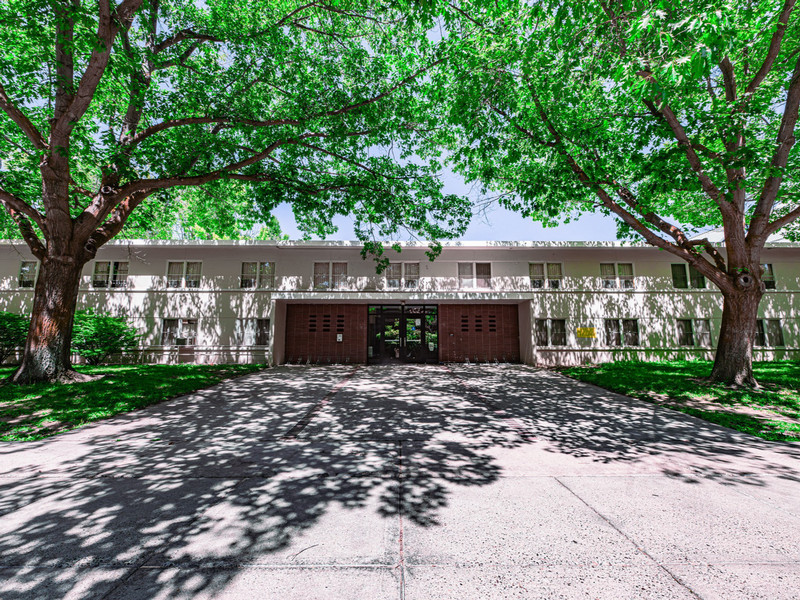 Two-story residence hall with trees and grass around it